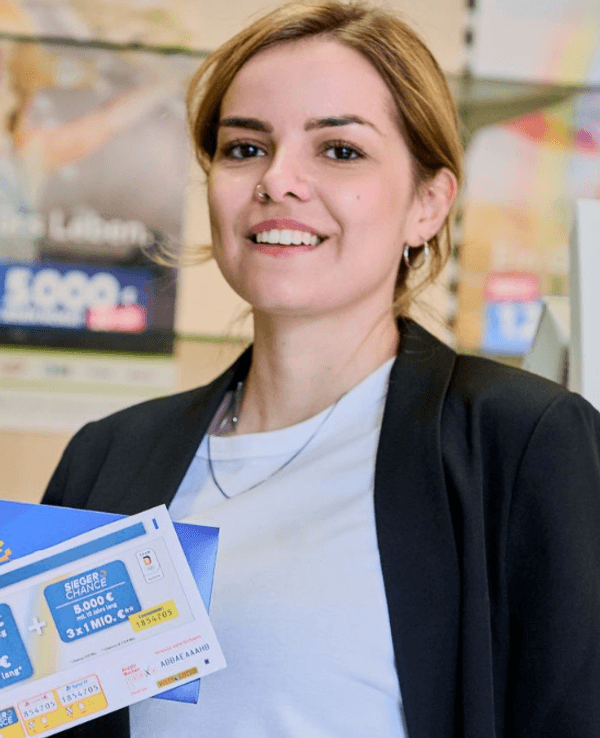 Eine Frau in einer WestLotto-Annahmestelle, die eine Spielquittung für ein Los der GlücksSpirale in der Hand hält.