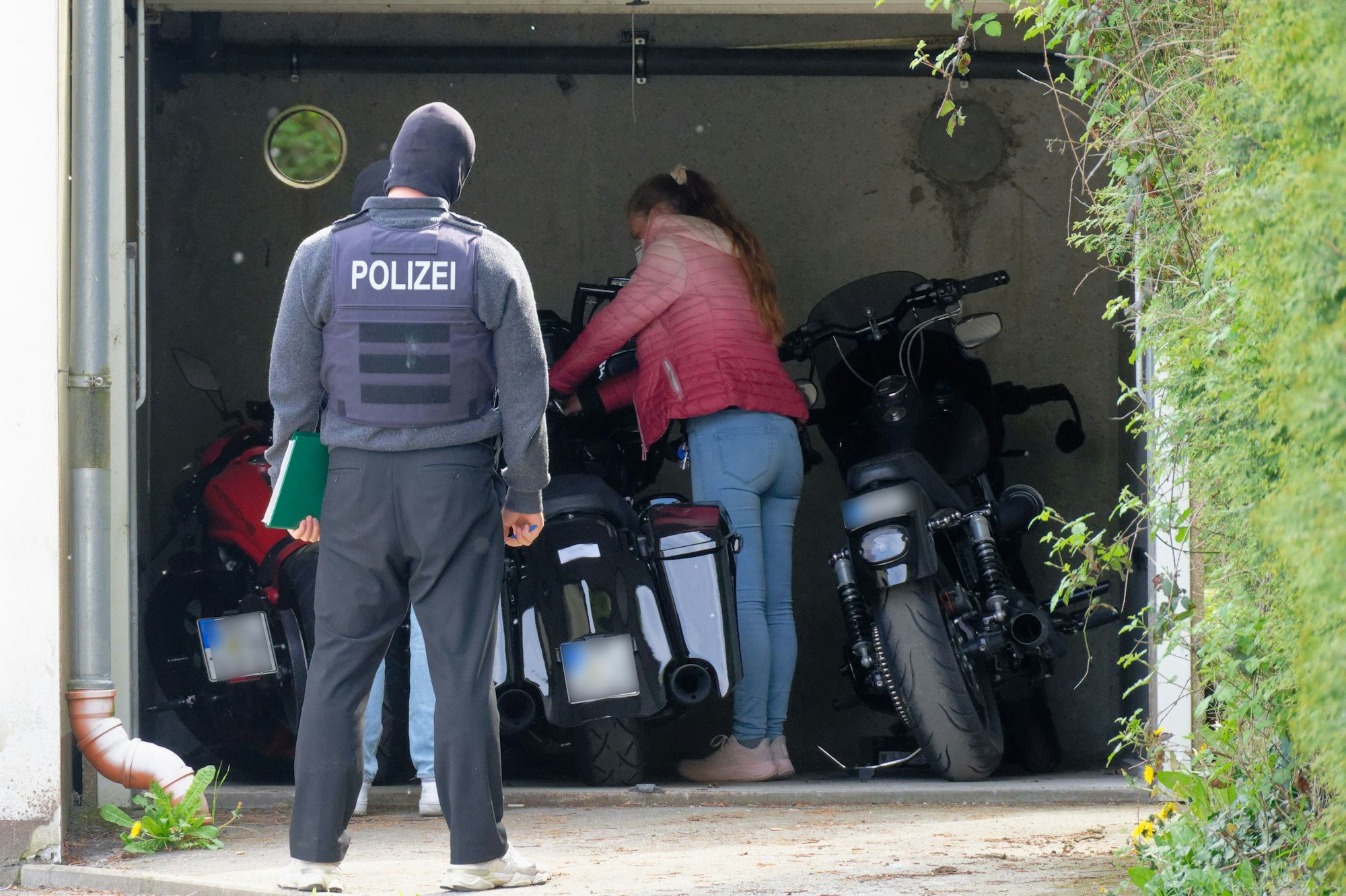 Motorräder stehen auf dem Gelände eines Anwesens, auf dem eine Razzia gegen die „Hells Angels“ durchgeführt wird, in einer Garage. Mit einer großangelegten Razzia geht die Polizei in Nordrhein-Westfalen gegen die Rockergruppe vor.