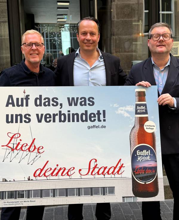 Thomas Deloy, Heinrich Philipp Becker und Künstler Merlin Bauer zeigen ein Poster.