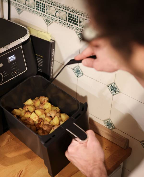 Mann kocht mit einem Airfryer