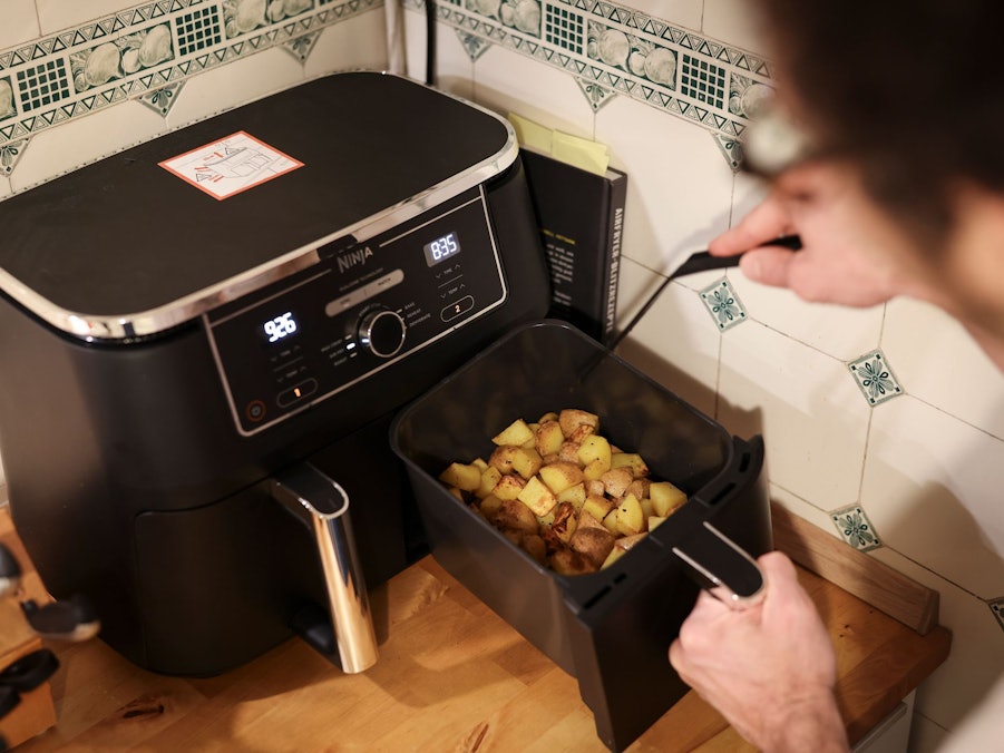 Mann kocht mit einem Airfryer