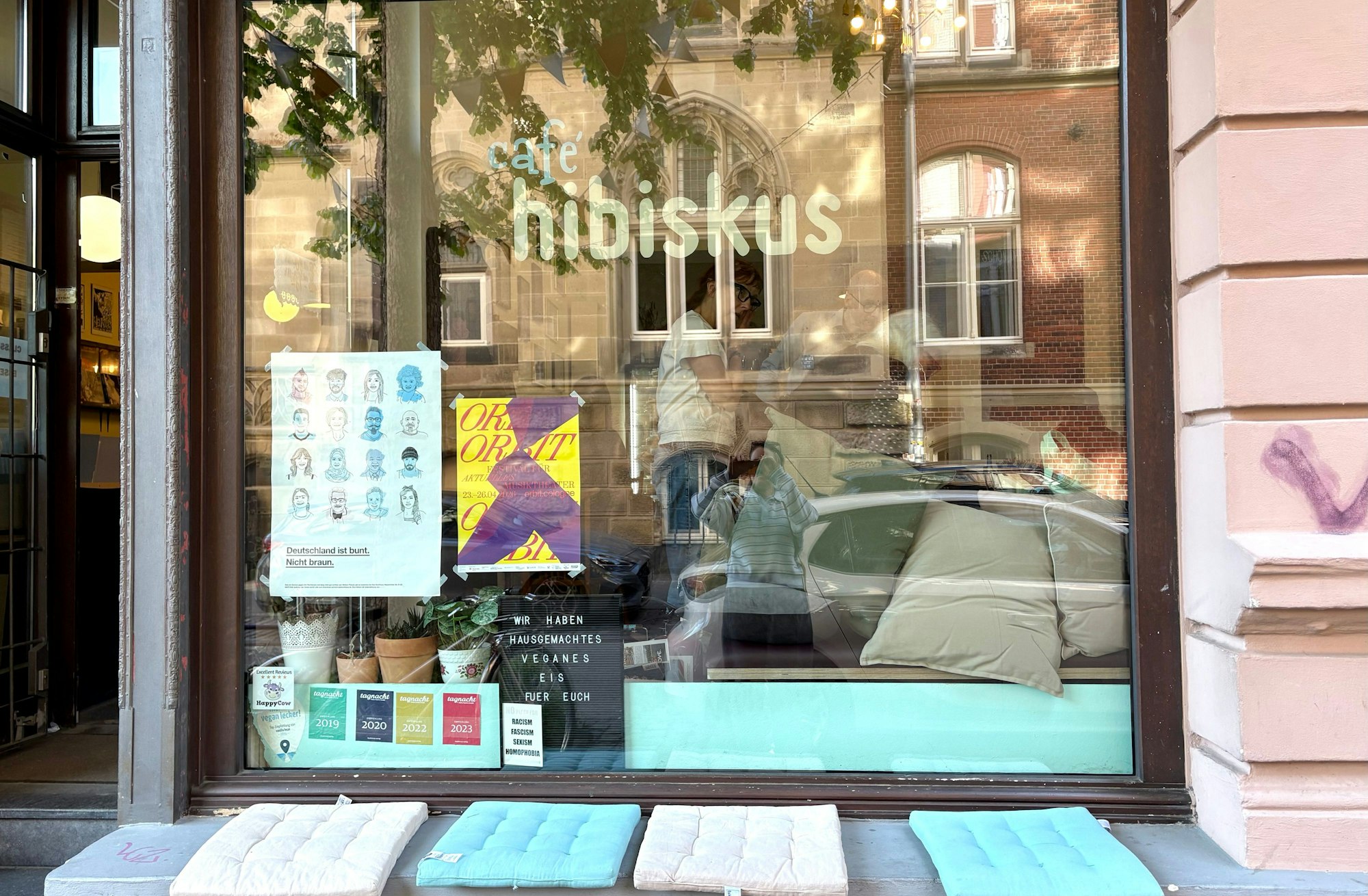 Das Café Hibiskus von außen in der Ritterstraße, in der auch ein Tattoo-Laden, Record-Store und Comicgeschäft zu finden sind.