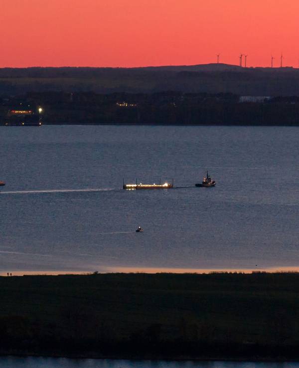 Das Schiff „Robin Hood“ zieht am Abend vor Wismar die Barge mit dem gestrandetem Wal in Richtung Ostsee (Luftaufnahme mit einer Drohne).