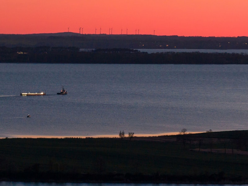 Das Schiff „Robin Hood“ zieht am Abend vor Wismar die Barge mit dem gestrandetem Wal in Richtung Ostsee (Luftaufnahme mit einer Drohne).