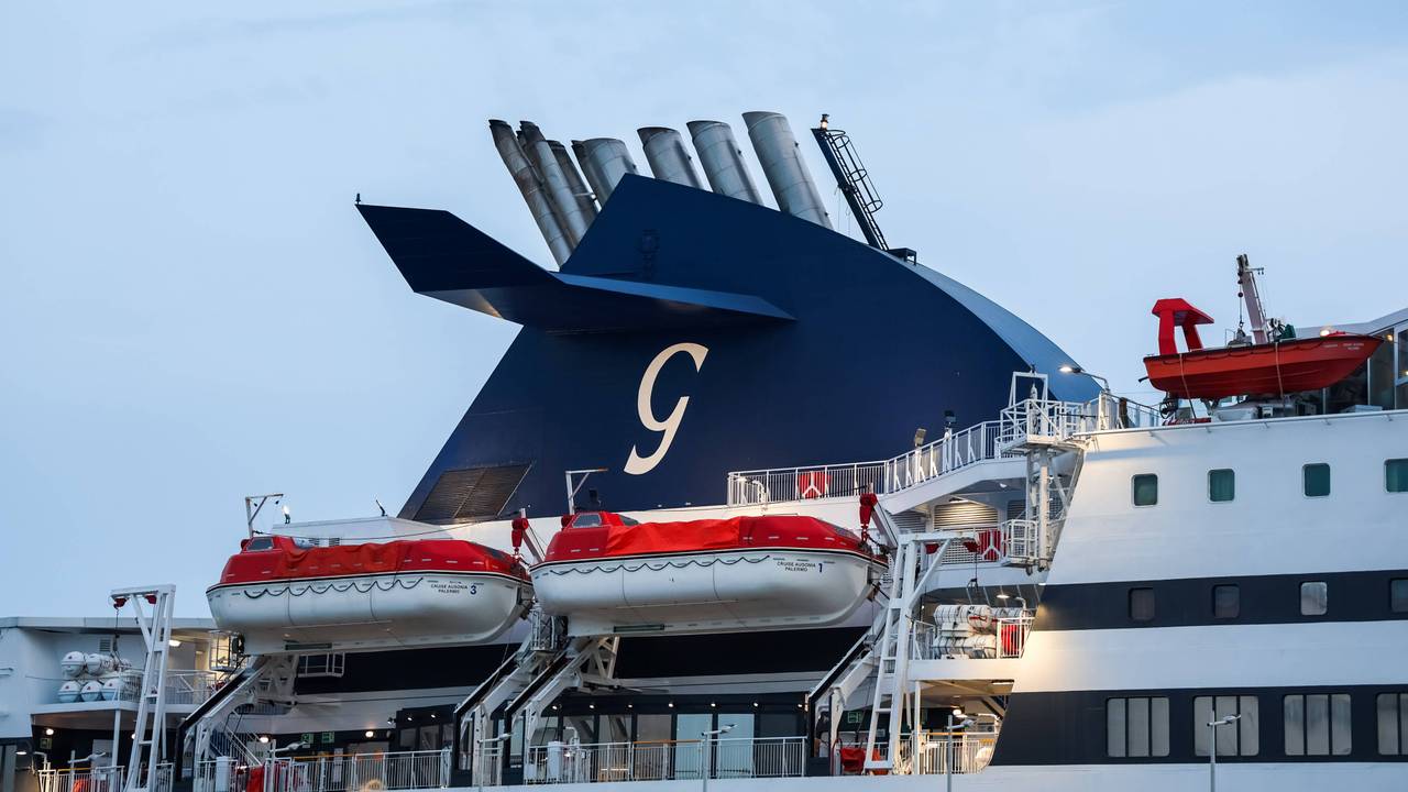 Schornstein eines Fährschiffs mit einem G-Logo und mehreren Rettungsbooten zur Sicherheit der Passagiere.