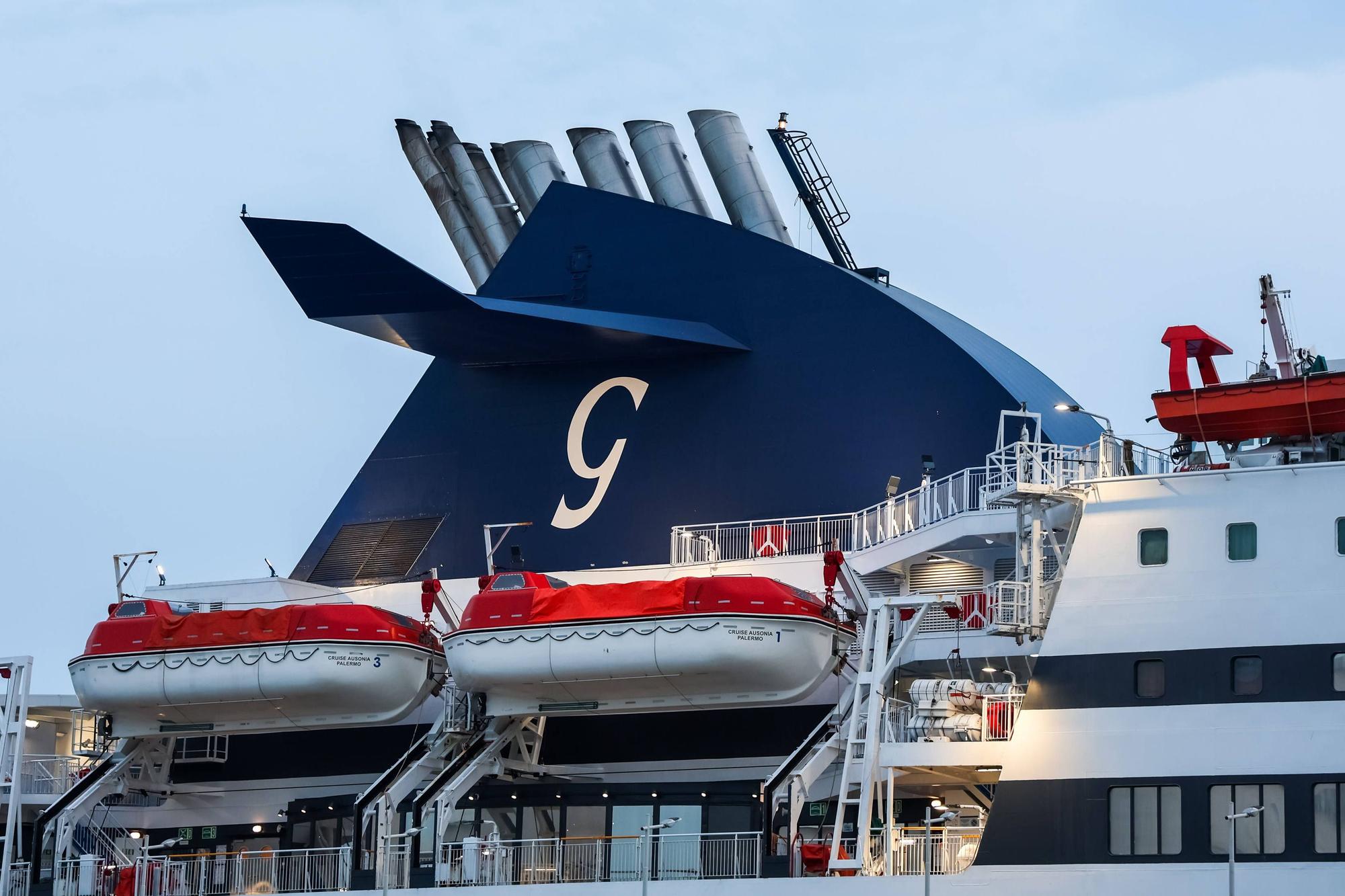Schornstein eines Fährschiffs mit einem G-Logo und mehreren Rettungsbooten zur Sicherheit der Passagiere.