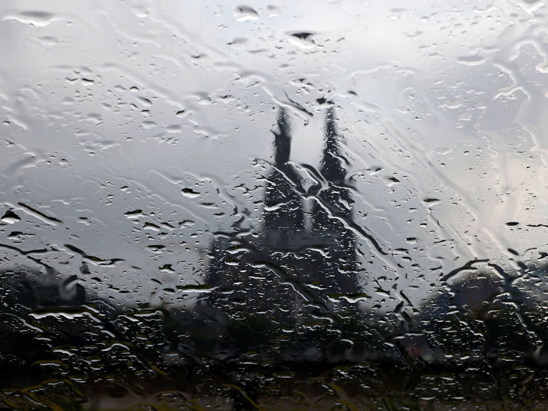 Der Kölner Dom gesehen durch eine Glasscheibe mit Regentropfen.