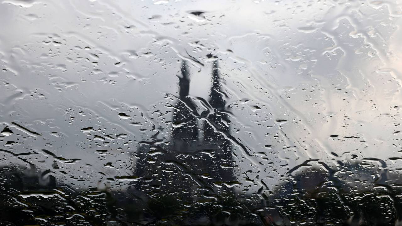 Der Kölner Dom gesehen durch eine Glasscheibe mit Regentropfen.