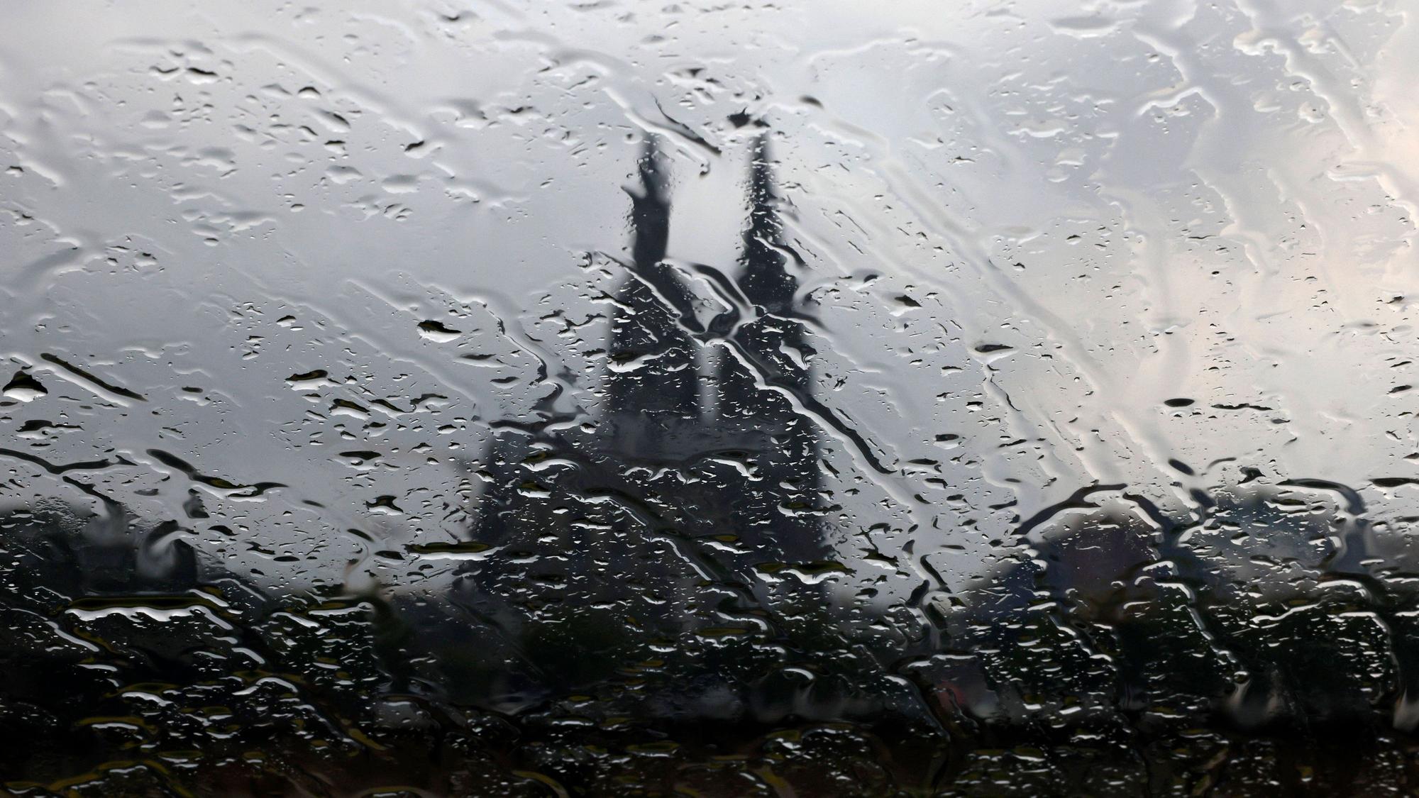 Der Kölner Dom gesehen durch eine Glasscheibe mit Regentropfen.
