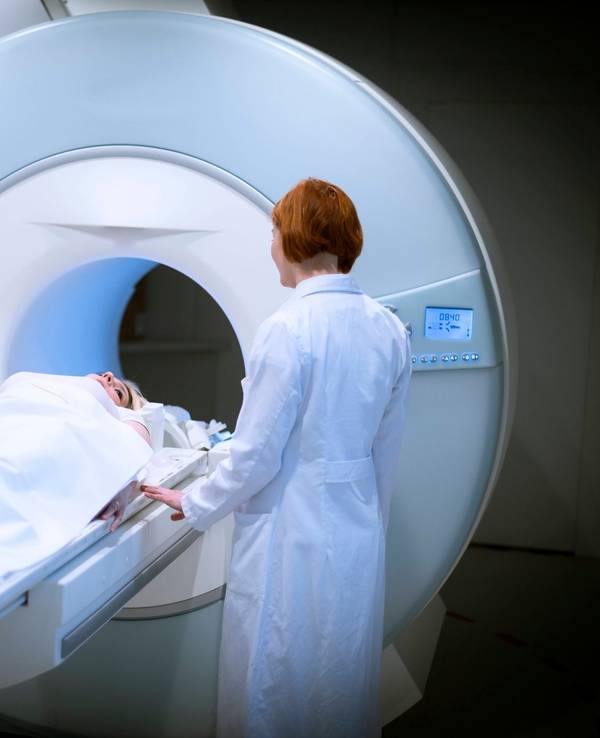 Ärztin bereitet eine Patientin für ein MRT vor