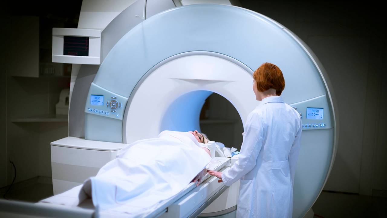 Ärztin bereitet eine Patientin für ein MRT vor