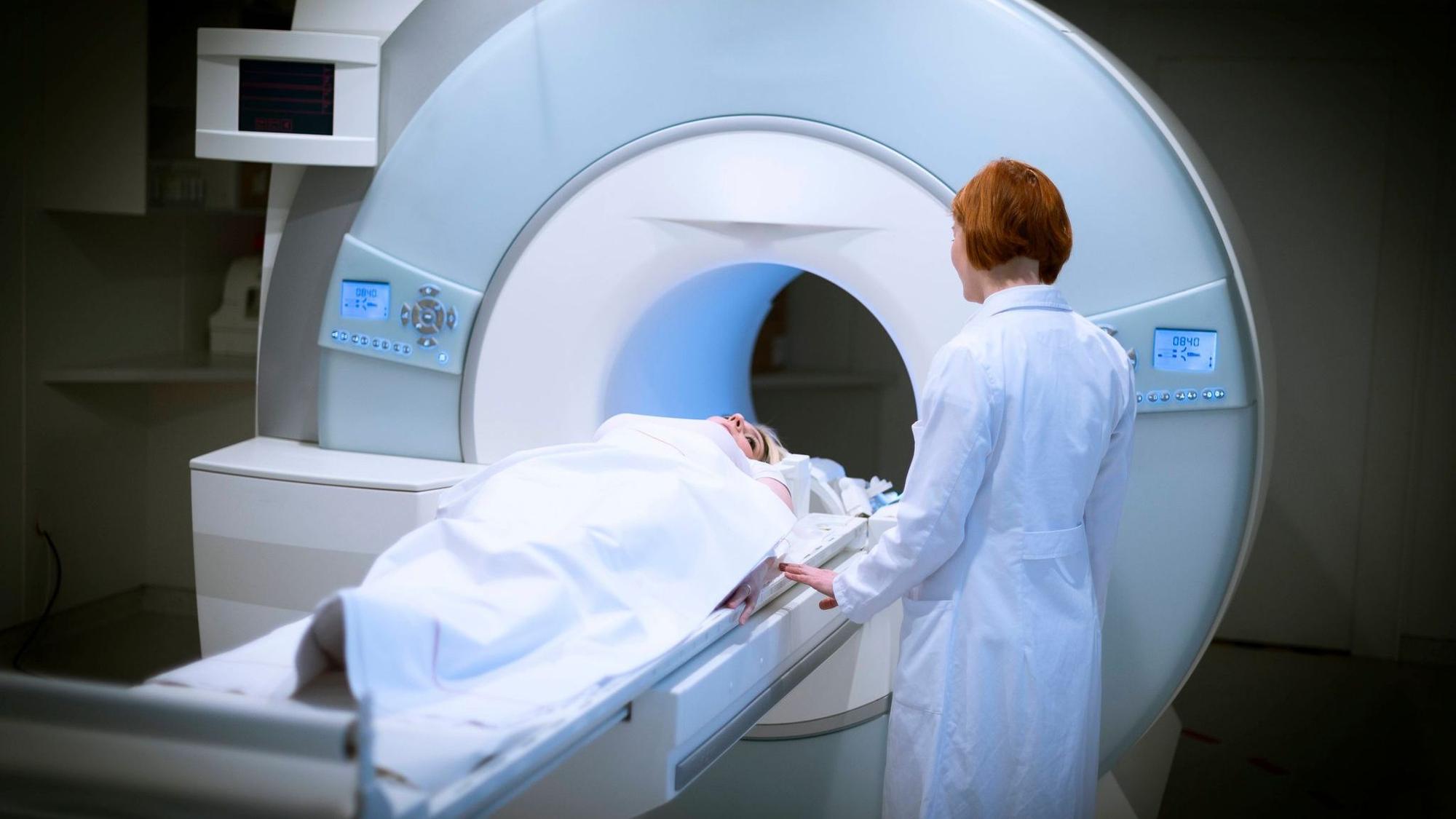 Ärztin bereitet eine Patientin für ein MRT vor