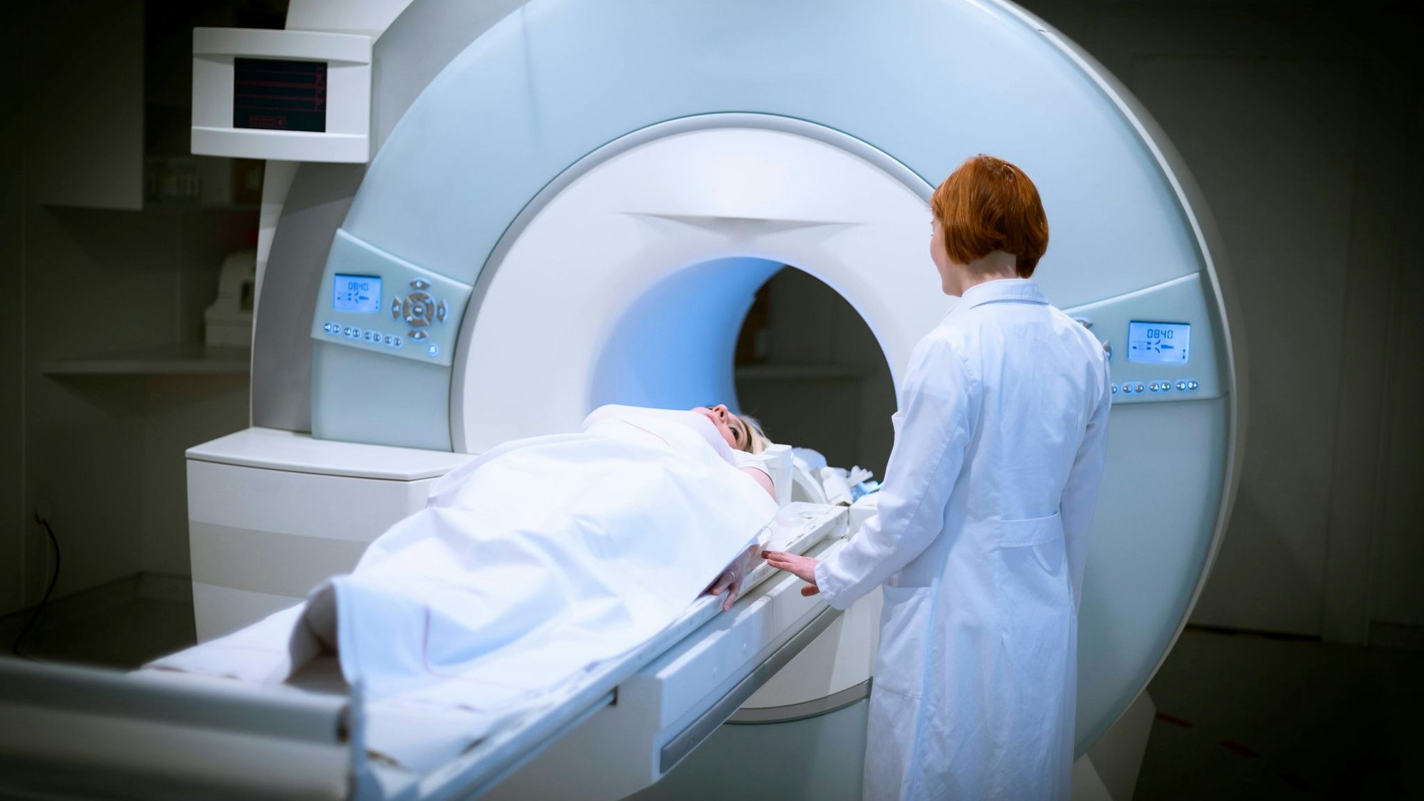 Ärztin bereitet eine Patientin für ein MRT vor