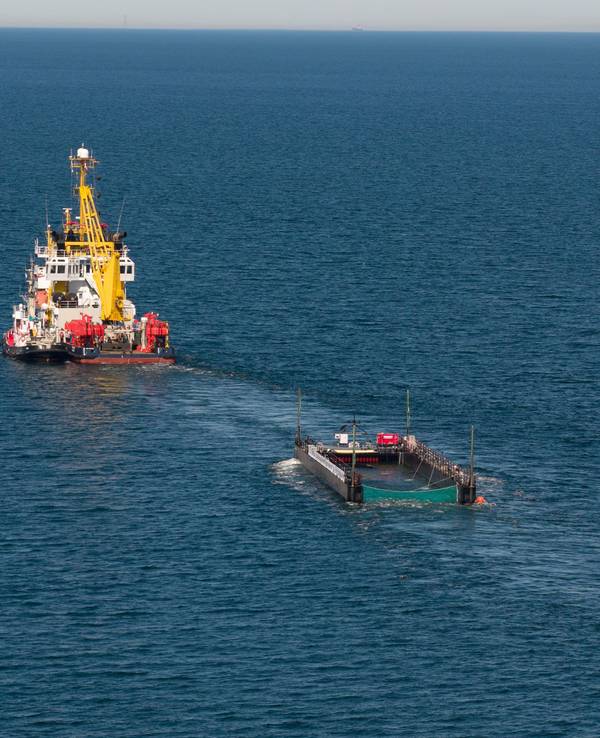 Der Schlepper zieht den mit Wasser gefüllten Lastkahn mit dem Buckelwal.