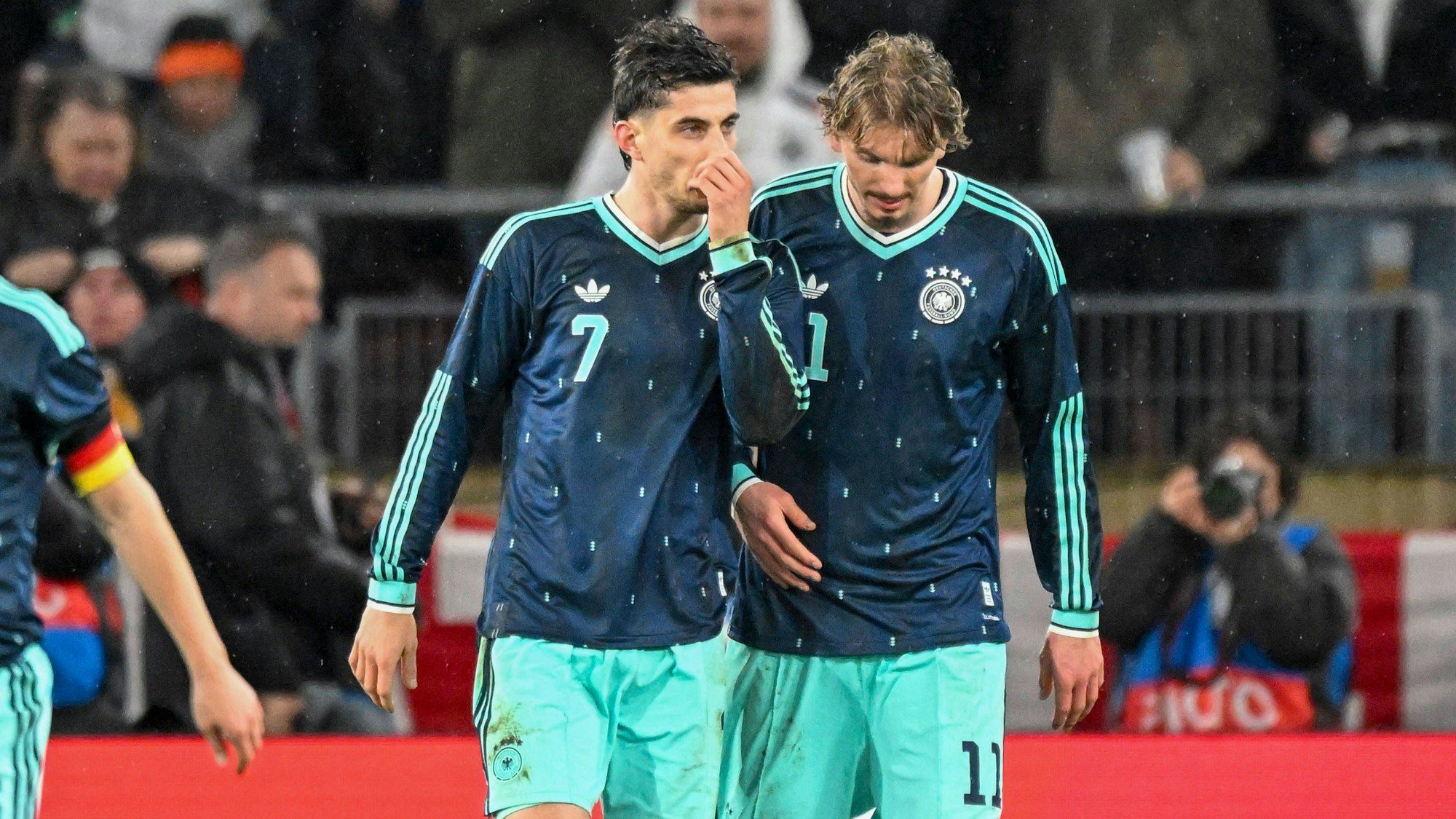 Kai Havertz (l.) und Nick Woltemade unterhalten sich auf dem Spielfeld.