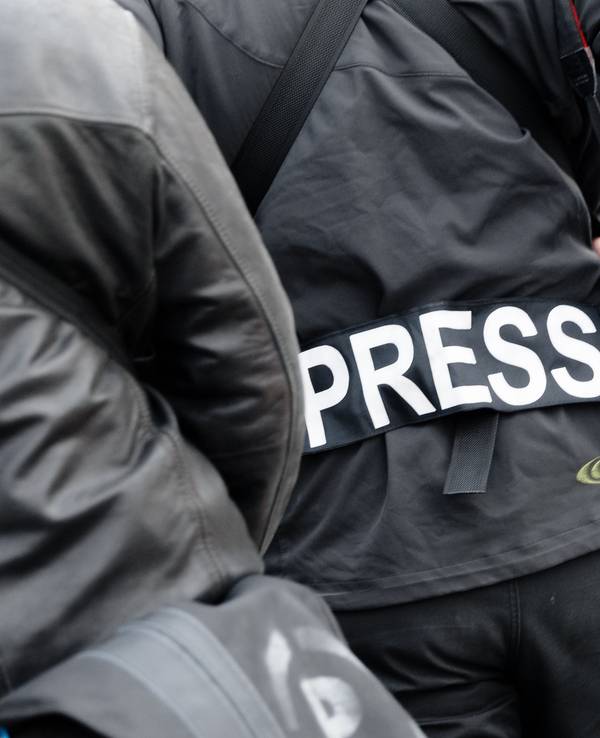 Ein Fotoreporter trägt einen Aufnäher mit dem Text «PRESS» auf seiner Jacke.