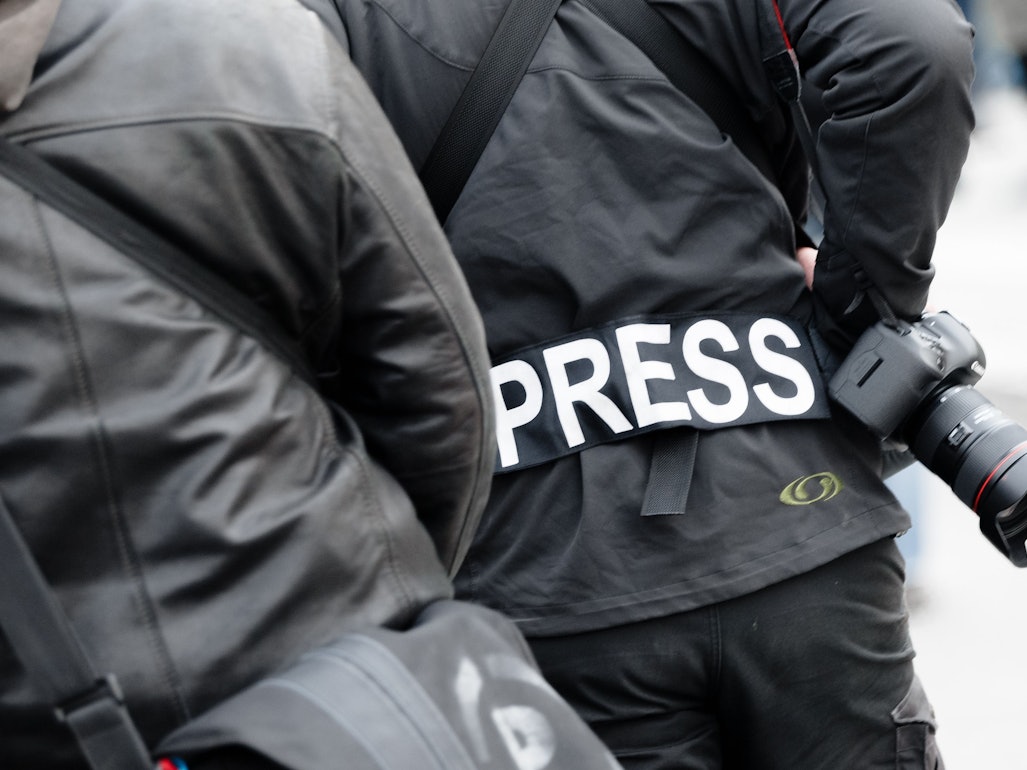 Ein Fotoreporter trägt einen Aufnäher mit dem Text «PRESS» auf seiner Jacke.