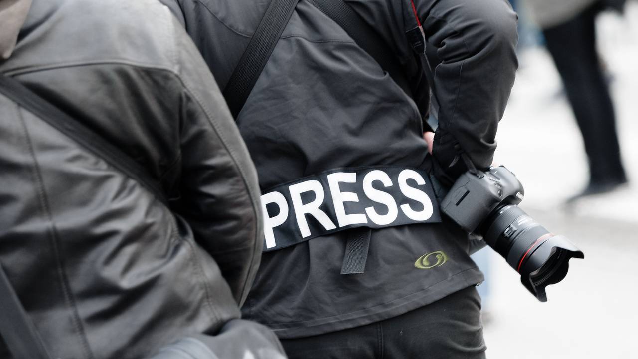 Ein Fotoreporter trägt einen Aufnäher mit dem Text «PRESS» auf seiner Jacke.