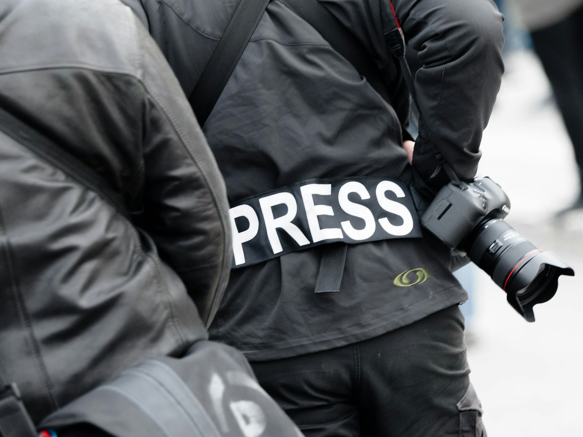 Ein Fotoreporter trägt einen Aufnäher mit dem Text «PRESS» auf seiner Jacke.
