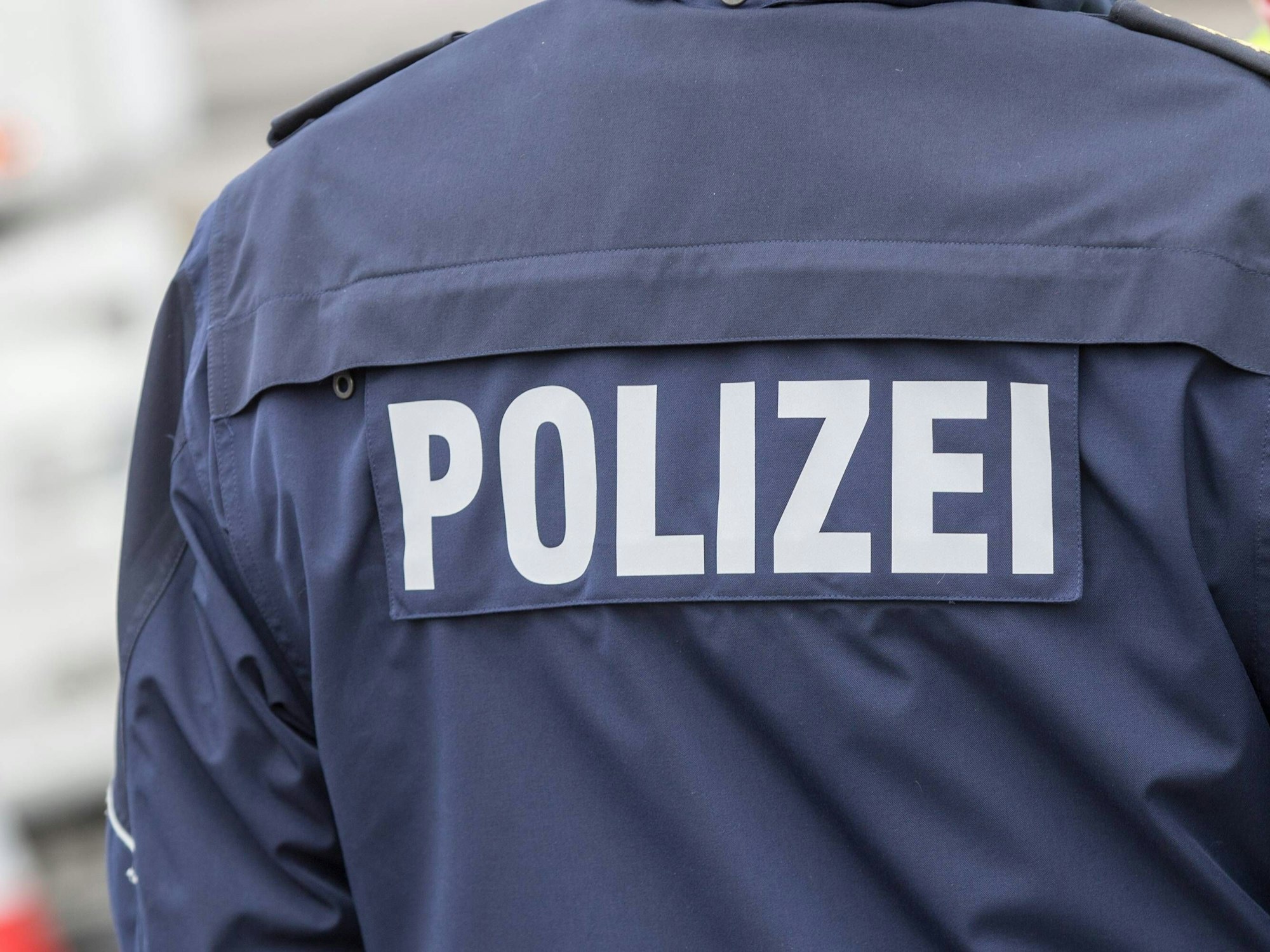 Der Betrüger trug eine schwarze Kappe, schwarze Kleidung und eine schwarze Weste mit dem weißen Aufdruck „Polizei“. (Das Symbolfoto zeigt einen Polizisten im Einsatz)