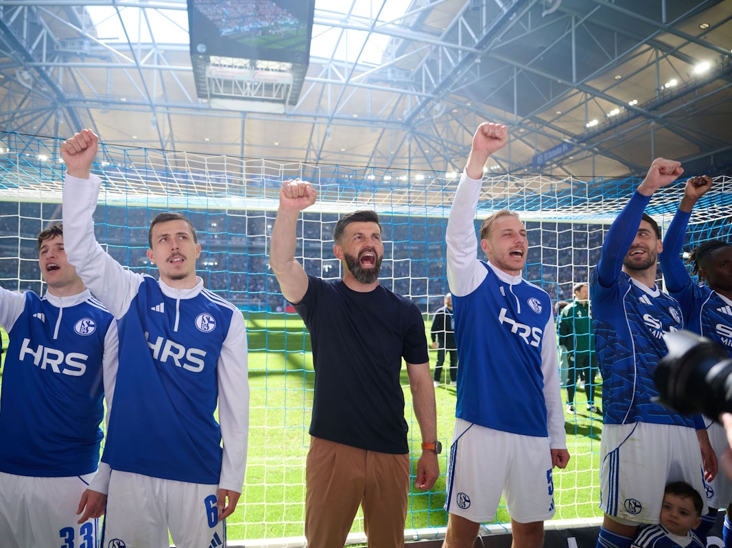 Miron Muslic, Ron Schallenberg und Timo Becker heben vor der Schalker Kurve die Faust.