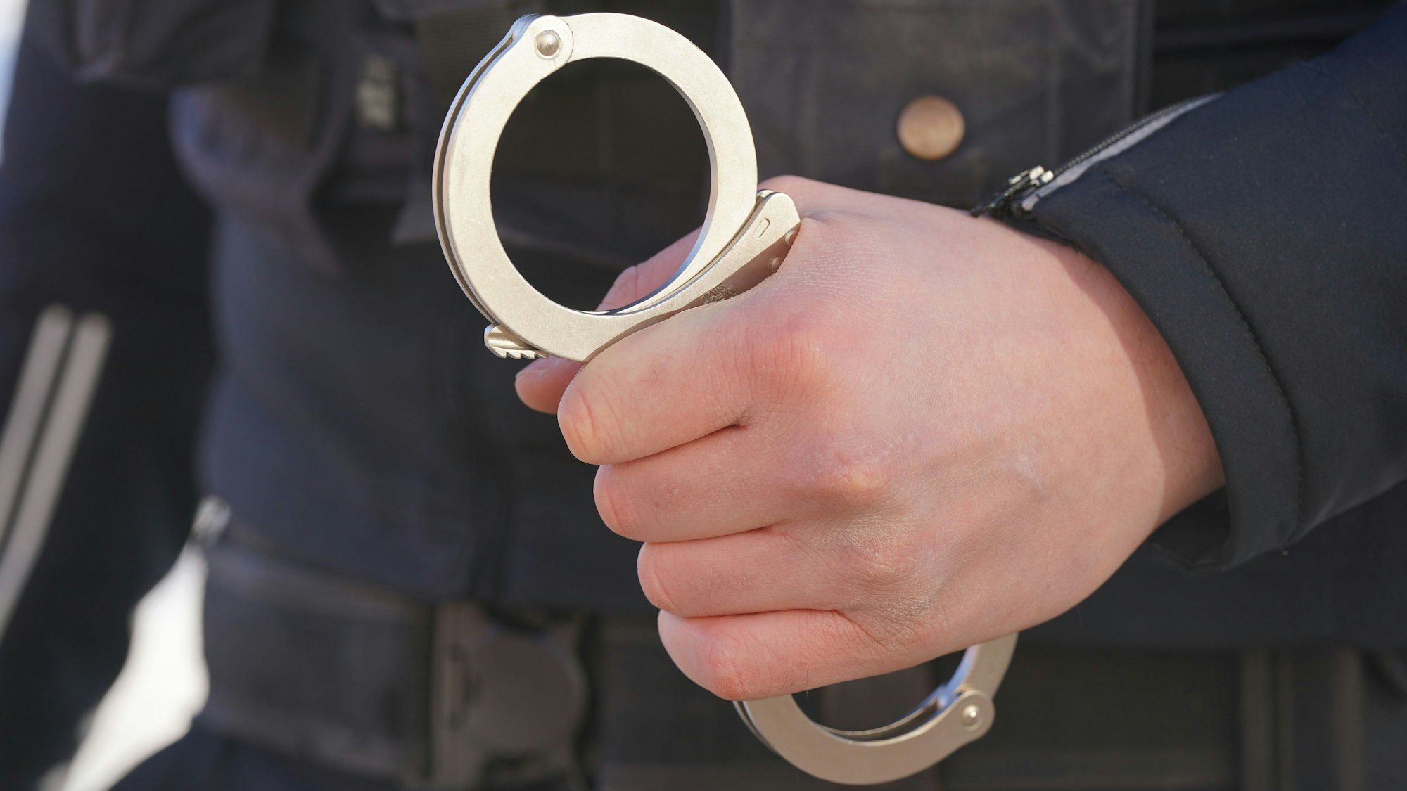 Ein Polizist hält Handschellen