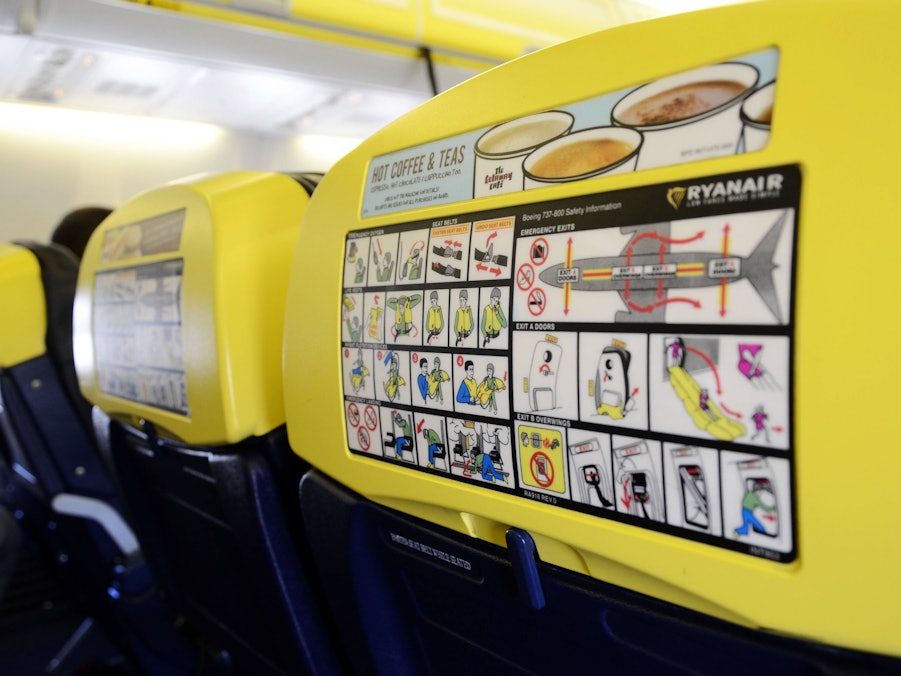 Sicherheitshinweise und Getränkeangebot auf Flugzeugsitzlehnen