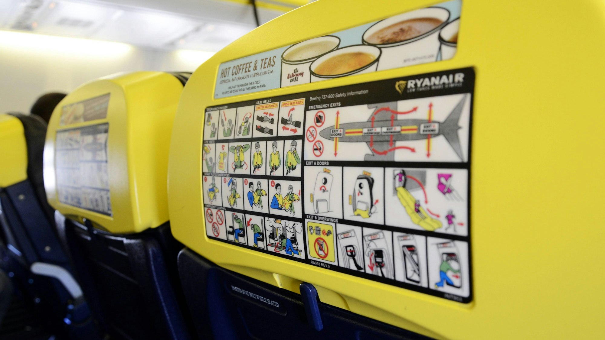Sicherheitshinweise und Getränkeangebot auf Flugzeugsitzlehnen