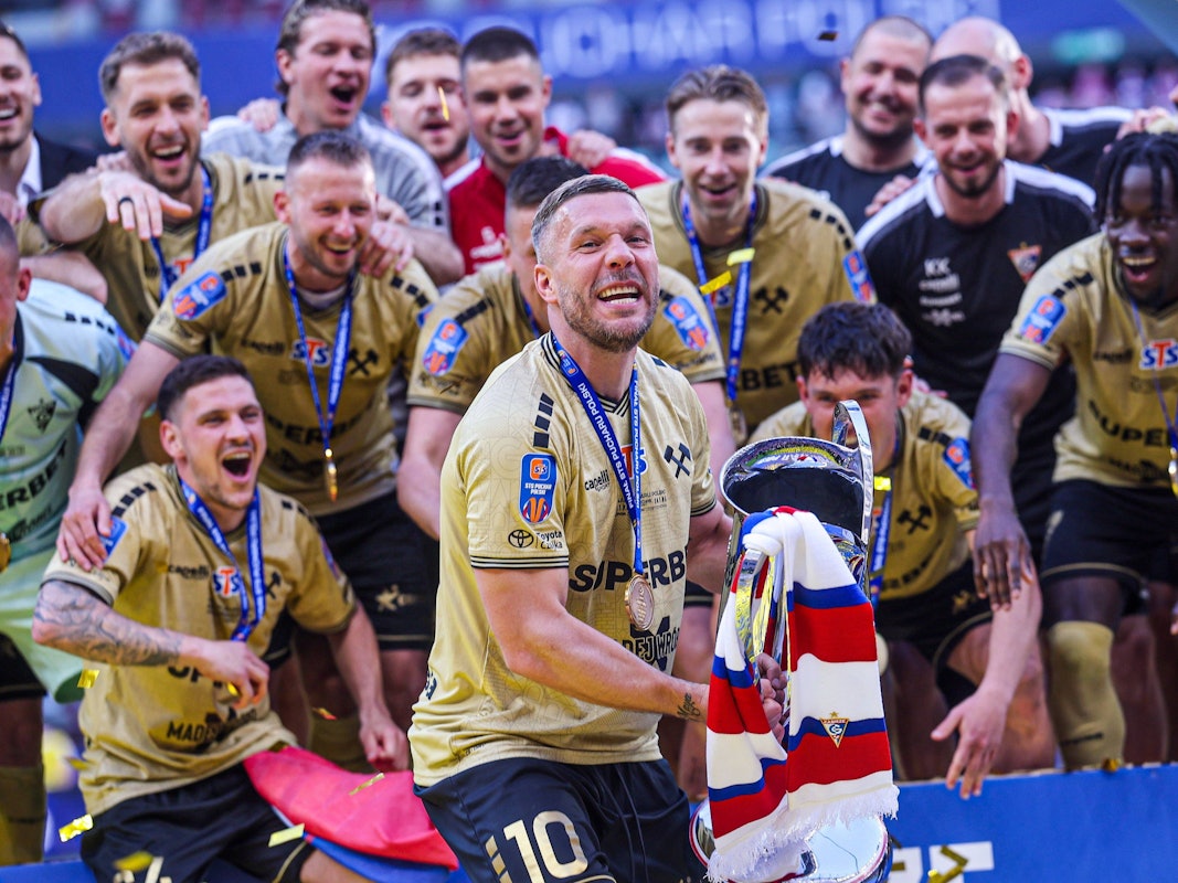 Lukas Podolski mit dem Pokal in den Händen.