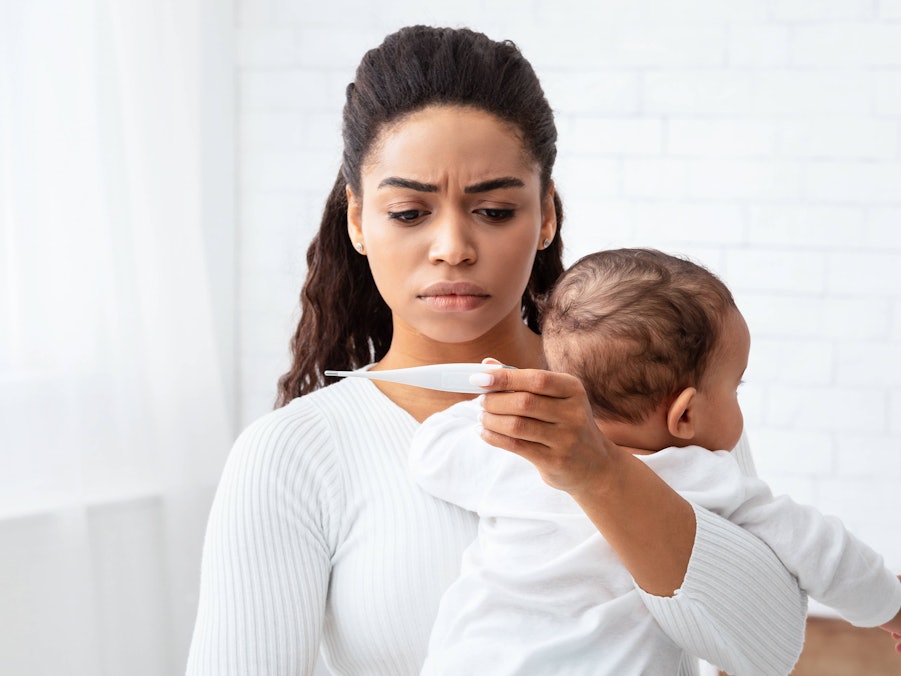 Afrikanische Mutter mit krankem Baby und Thermometer