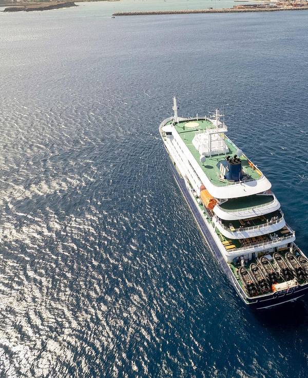 Diese Luftaufnahme zeigt das Kreuzfahrtschiff „MV Hondius“, das vor dem Hafen von Praia vor Anker liegt. Ein Ausbruch einer „schweren akuten Atemwegserkrankung“ an Bord des Schiffs hat zwei Todesopfer gefordert.