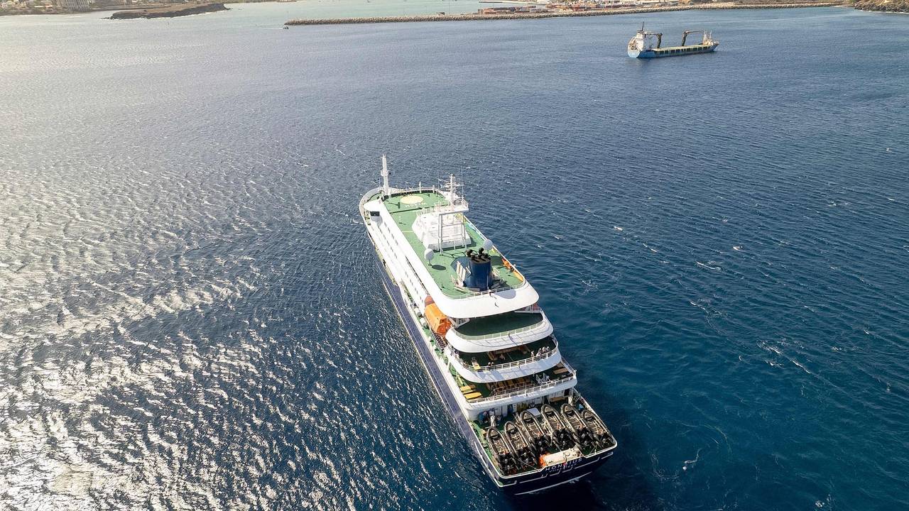 Diese Luftaufnahme zeigt das Kreuzfahrtschiff „MV Hondius“, das vor dem Hafen von Praia vor Anker liegt. Ein Ausbruch einer „schweren akuten Atemwegserkrankung“ an Bord des Schiffs hat zwei Todesopfer gefordert.