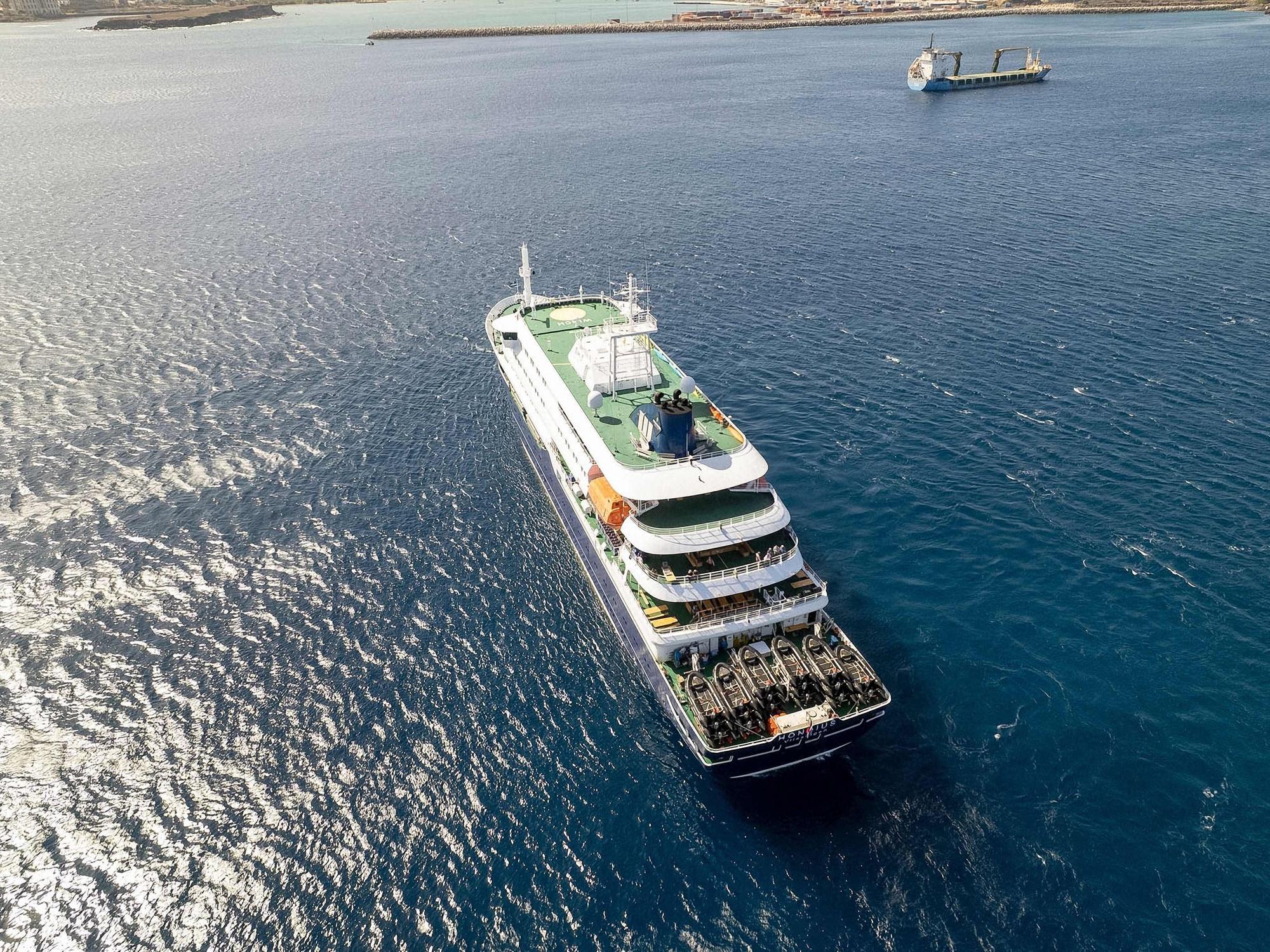 Diese Luftaufnahme zeigt das Kreuzfahrtschiff „MV Hondius“, das vor dem Hafen von Praia vor Anker liegt. Ein Ausbruch einer „schweren akuten Atemwegserkrankung“ an Bord des Schiffs hat zwei Todesopfer gefordert.
