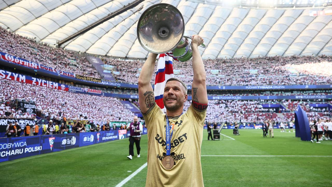 Lukas Podolski hält den polnischen Pokal in die Luft.