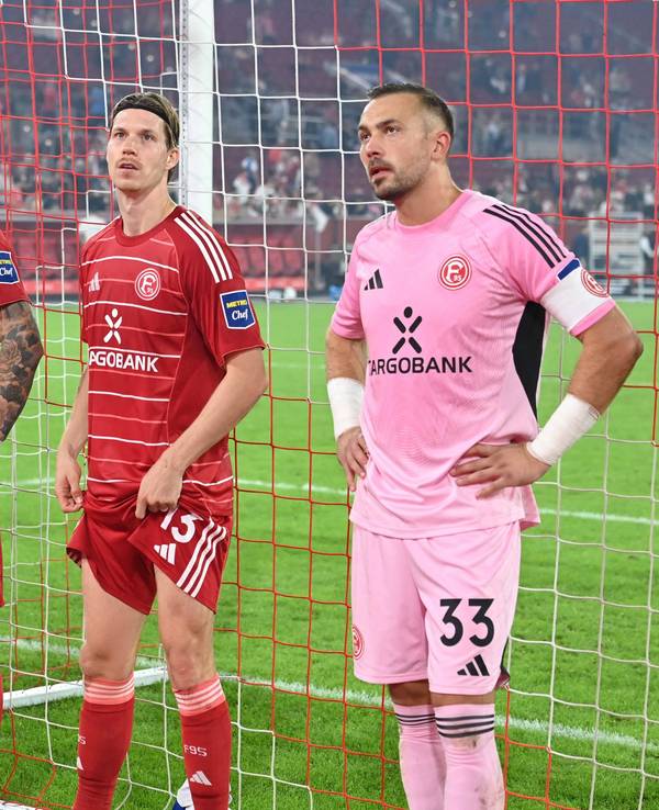 Die Spieler von Fortuna Düsseldorf stehen vor der Fankurve und sehen enttäuscht aus.