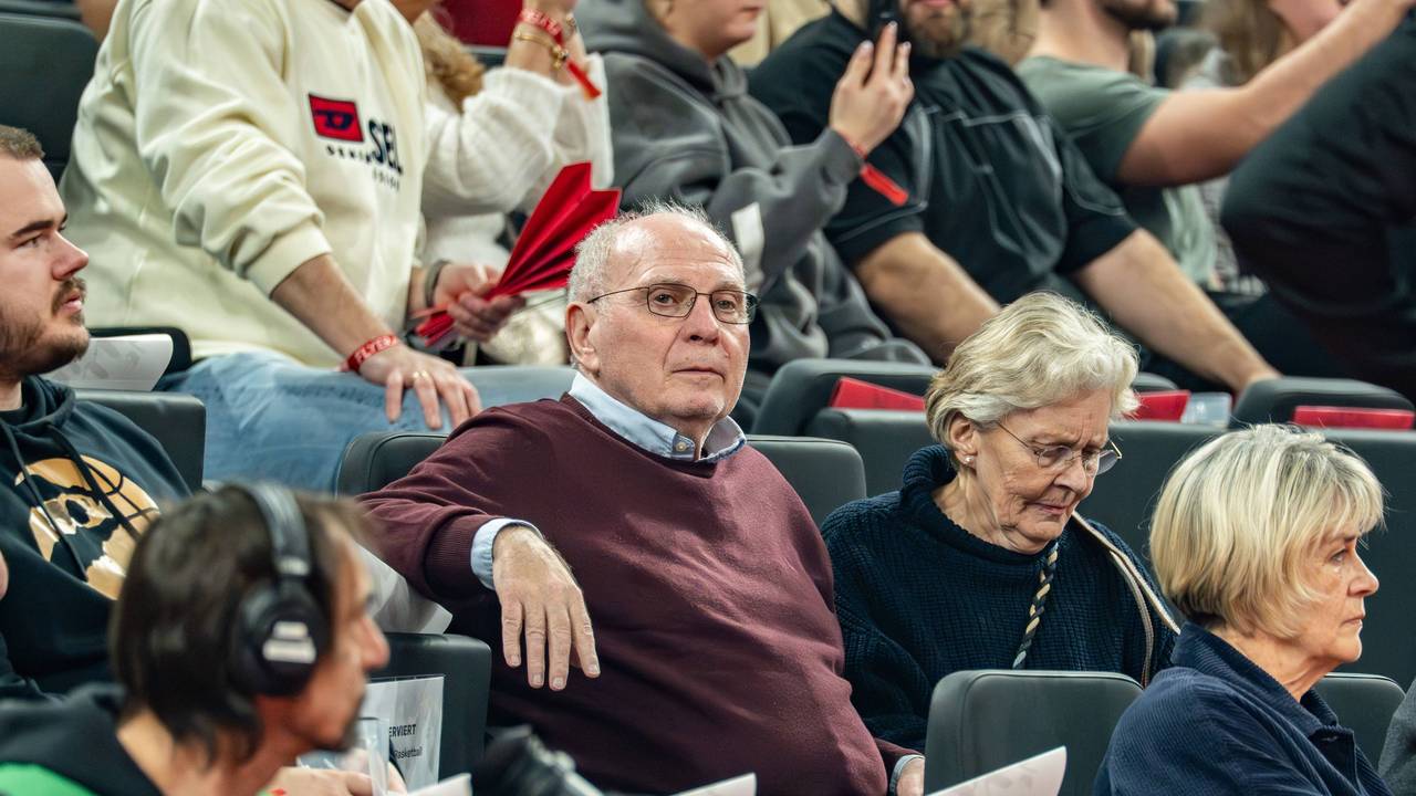 Uli Hoeneß sitzt bei einem Basketballspiel neben seiner Frau auf der Tribüne.