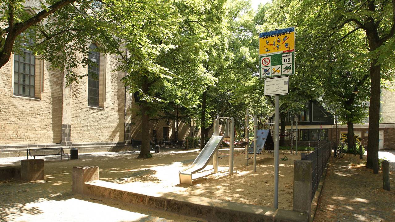 Kinderspielplatz mit Schild und Bäumen