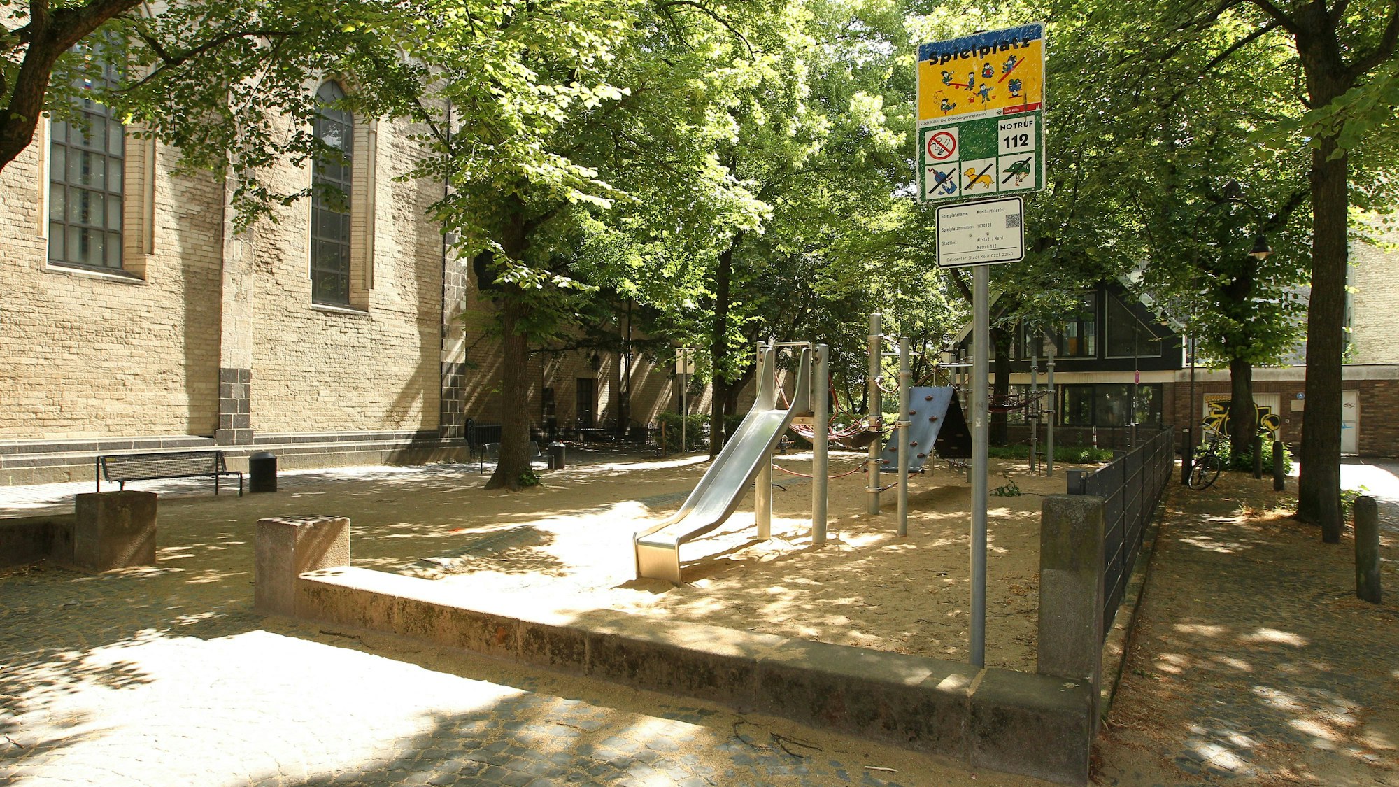 Kinderspielplatz mit Schild und Bäumen