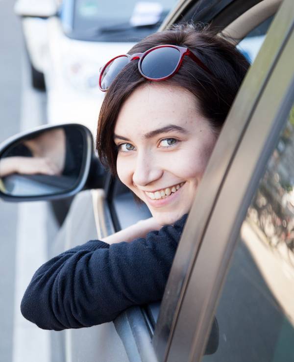 Eine junge Frau schaut aus einem Autofenster