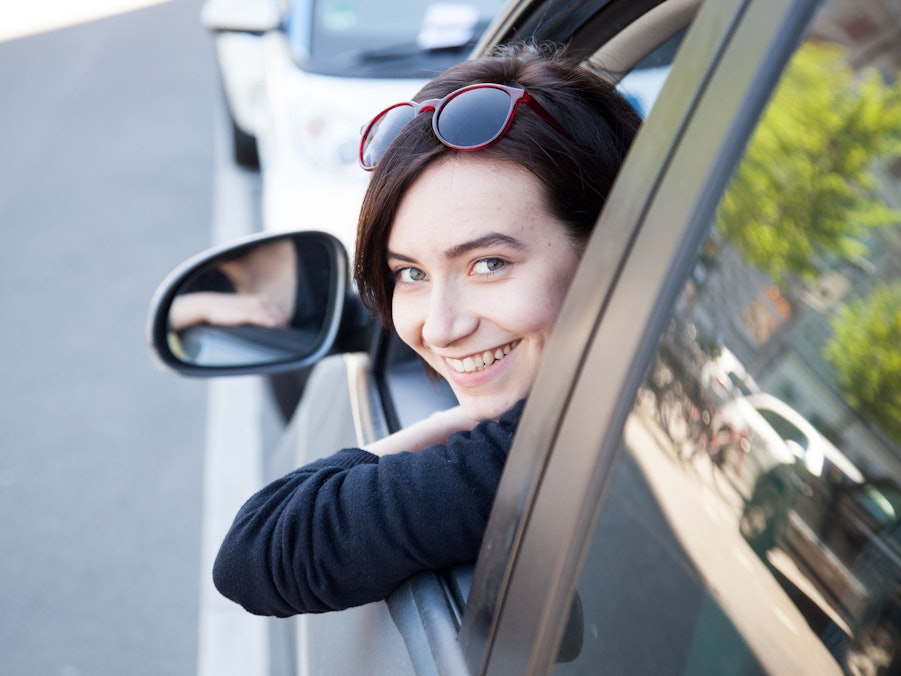Eine junge Frau schaut aus einem Autofenster