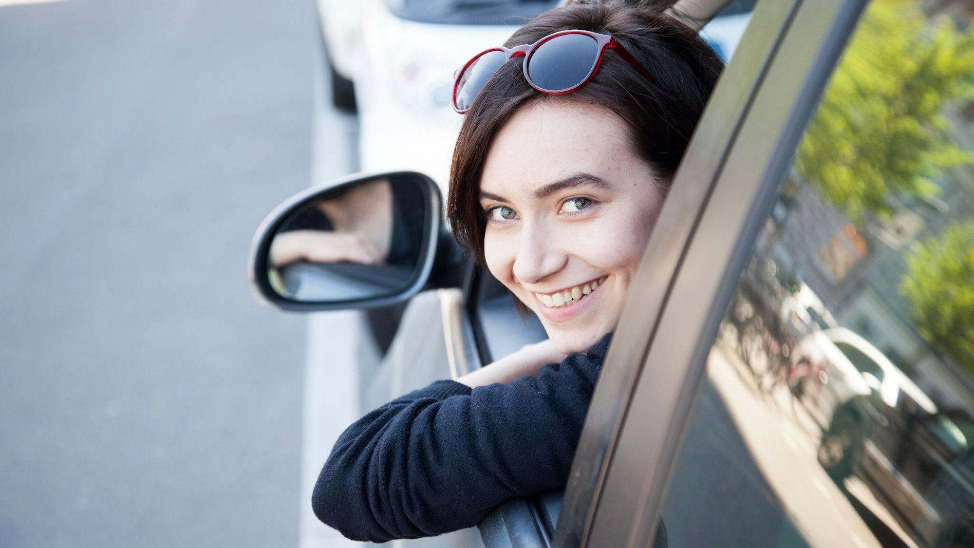 Eine junge Frau schaut aus einem Autofenster
