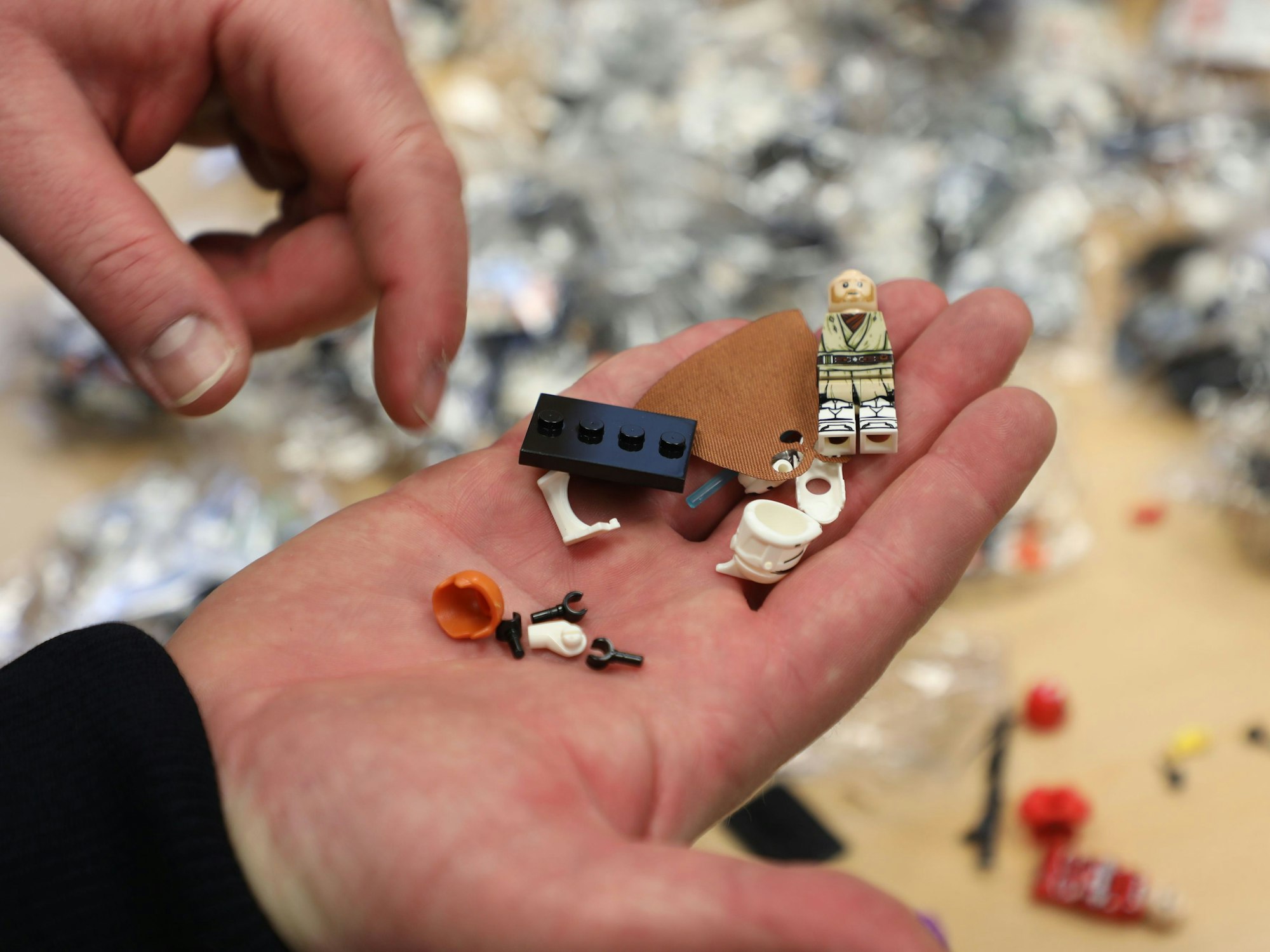 Ein Zollbeamter hält eine gefälschte Spielfigur und gefälschte Spielbausteine in der Hand. Der Zoll hat am Flughafen Köln/Bonn gefälschte Waren sichergestellt und verbrannt.