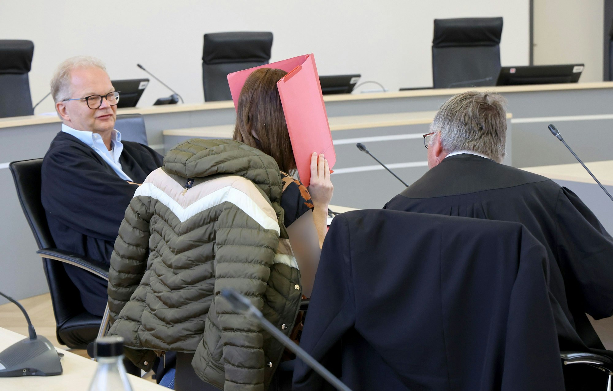 Die Anwälte Thomas Löcker und Andreas Ohm (v.l.) warten mit der Angeklagten im Saal des Landgerichts auf die Fortsetzung des Verfahrens wegen Mordes. Der Angeklagten wird vorgeworfen, heimtückisch und aus sonst niedrigen Beweggründen den zur Tatzeit achtjährigen Fabian aus Güstrow getötet zu haben.