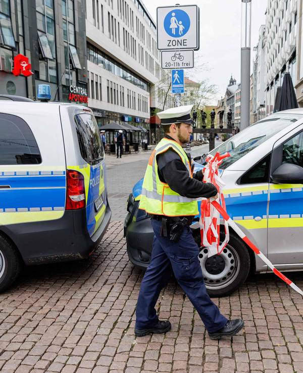 Ein Polizist entfernt am 5. Mai 2026 die Absperrung am Eingang zur Fußgängerzone der Grimmaischen Straße in Leipzig, unweit der Stelle, an der ein Auto in eine Menschenmenge gerast war und dabei zwei Menschen getötet und mehrere verletzt hatte.