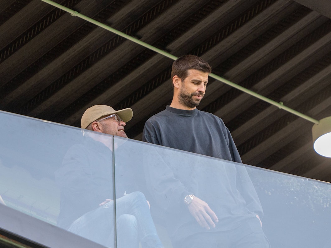 Gerard Piqué auf der Tribüne hinter einer Glasballustrade.