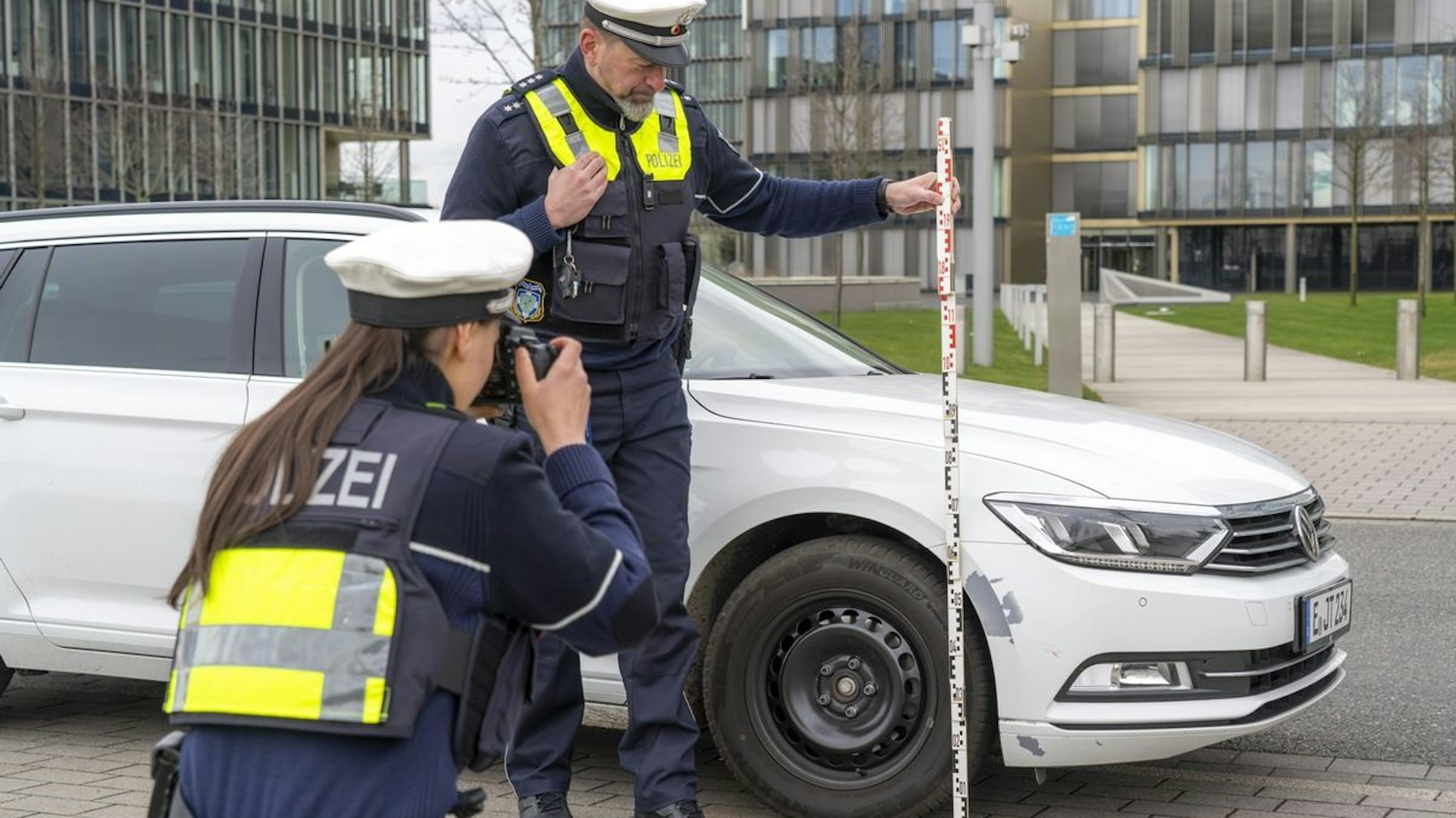 Ein Polizeiauto steht mit Blaulicht an einer Straße.