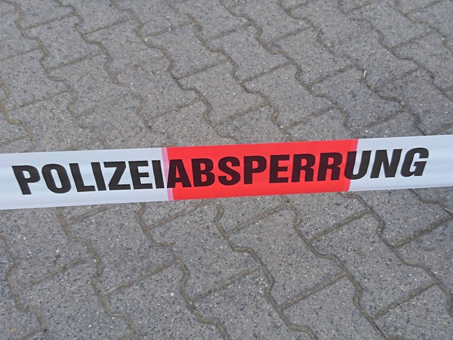 Symbolische Polizeiabsperrung auf Pflastersteinen