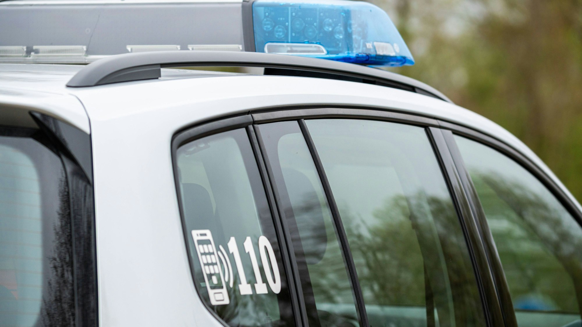 Polizeifahrzeug mit Blaulicht und Notrufnummer 110