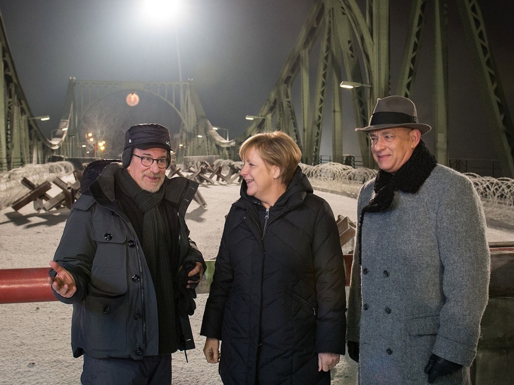 Ende 2014 drehte Starregisseur Steven Spielberg (links) mit Hollywoodstar Tom Hanks an und auf der Glienicker Brücke Szenen für den Historienfilm „Bridge of Spies“. Einen Besuch am Set ließ sich die damalige Kanzlerin Angela Merkel nicht entgehen. (Bild: Guido Bergmann/Bundesregierung via Getty Images)