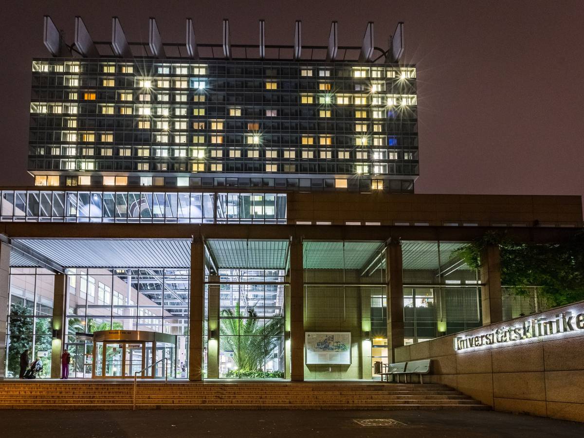 Das Hauptgebäude der Universitätskliniken Köln ist am Abend hell erleuchtet.